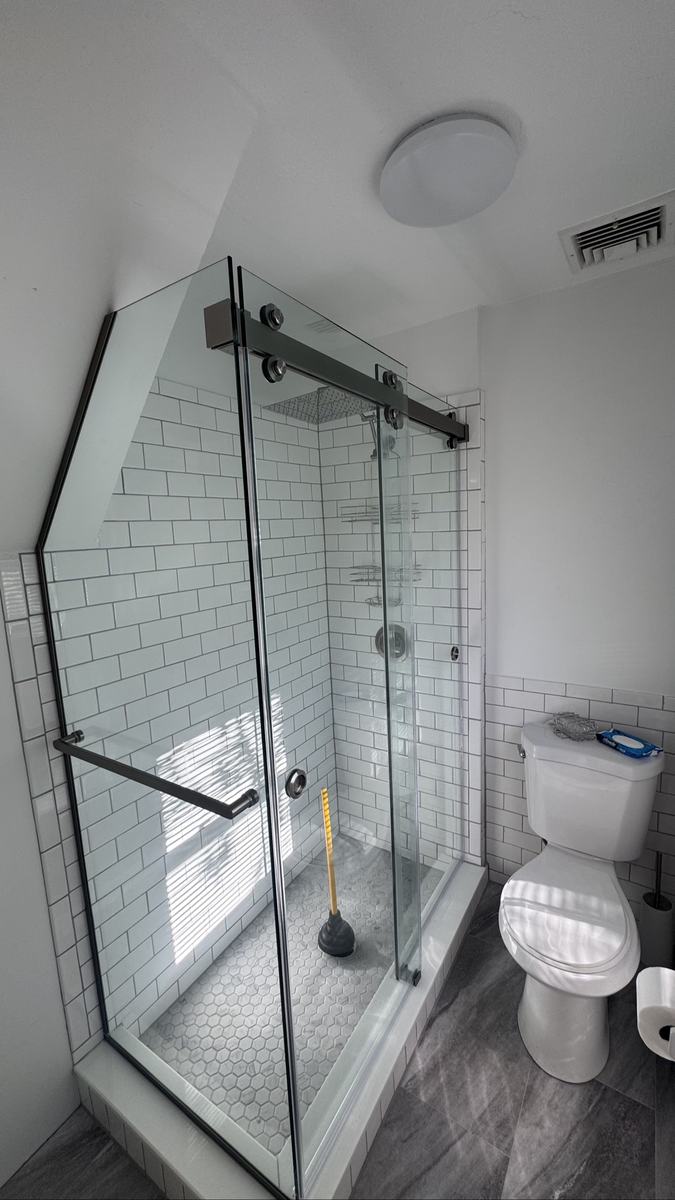 Frameless double sliding shower doors with brushed nickel hardware